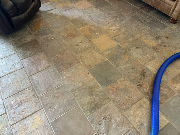 Worn stone tile floor showing stains and surface damage before restoration